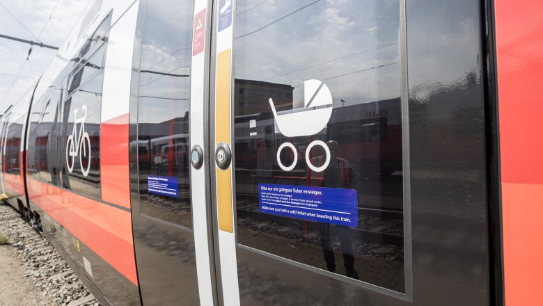 Train, © Weinviertel Tourismus GmbH / Herbst Close-up of a train door with symbols for bicycles and baby carriages.