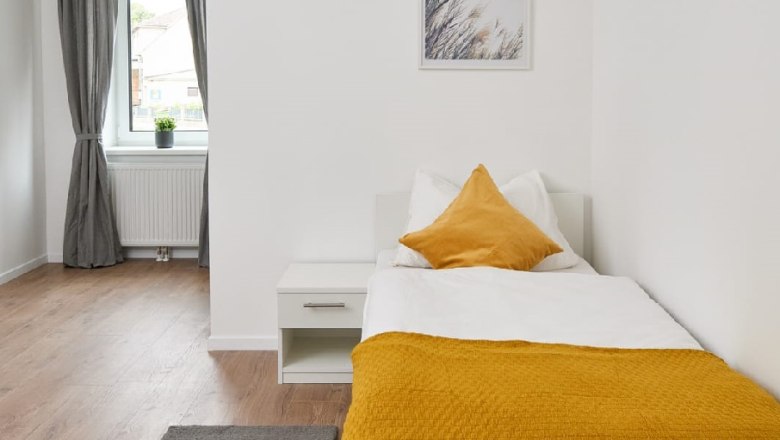 Single room, © Eugenia Husti Single room with bed, bedside table and window with curtains.