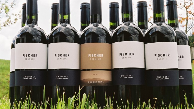 Wines, © Weingut Fischer Several Fischer wine bottles are standing in the grass.