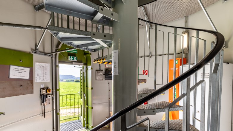 Lichtenegg wind turbine - Ascent to the platform, © Wiener Alpen, Christian Kremsl Interior view of a wind turbine with spiral staircase and open door to the outside.