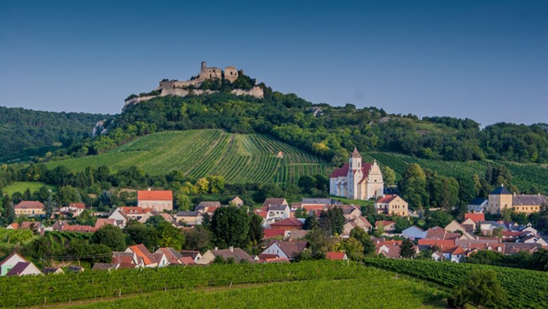 Wine village Falkenstein, © Clara J. Körner-Schreiber Panorama of Falkenstein with vineyards, a church and a ruined castle on a hill.