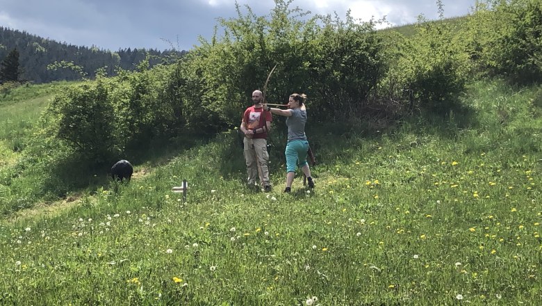 3D archery course, © Herwig Kerbl Two people on a meadow doing archery, surrounded by green nature and bushes.