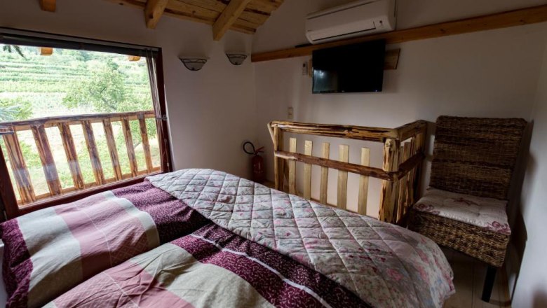Sleeping area in the tree house, © Familie Feiertag Double bed with colorful bed linen
