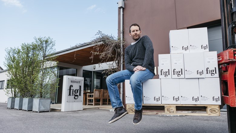 Winery Leopold Figl, © David Schreiber A man sits on stacked wine cartons in front of the Leopold Figl winery.