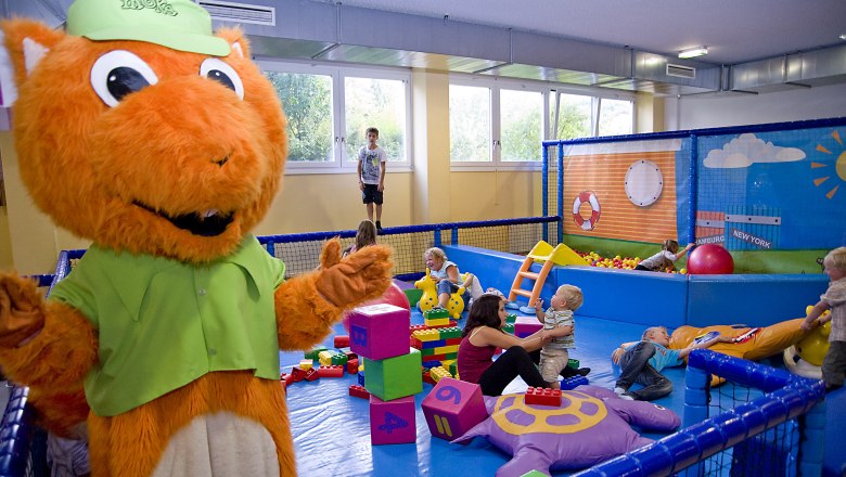 kids space Toddler area, © kids space gars Children play in an indoor play area with a large orange mascot.
