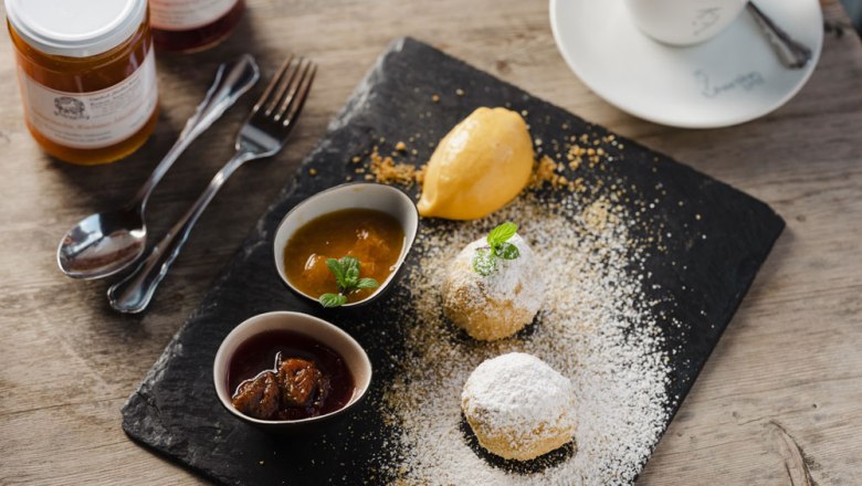 Apricot dumplings, homemade chutneys, © Niederösterreich Werbung/Michael Reidinger Apricot dumplings with smoked pork served on a slate plate.