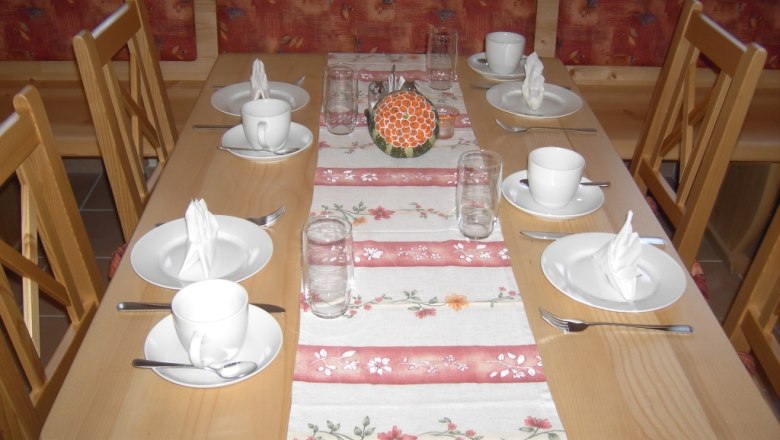 Breakfast room, © Gästehaus Denk A laid table in a breakfast room with crockery and glasses.