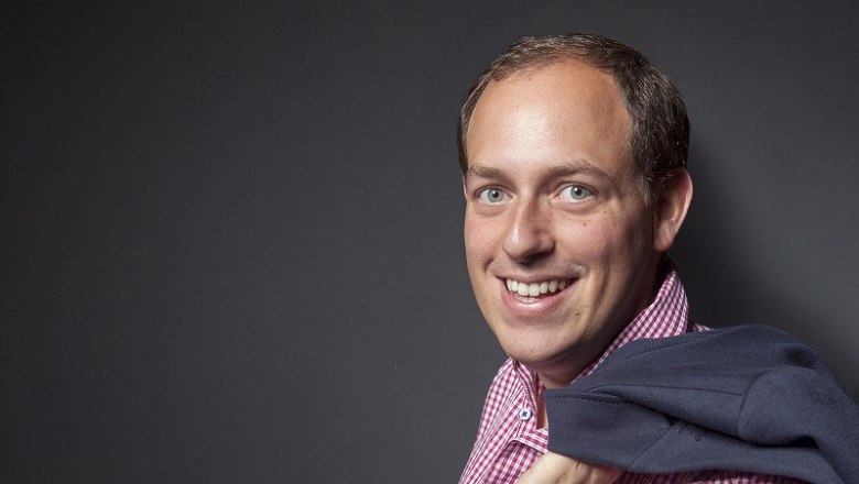 Gilg Winery, © Alexander Seidl Man in plaid shirt with jacket over his shoulder in front of a gray background.