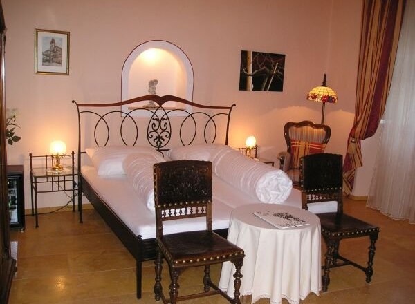 Summer dream room, © Roisl Cozy bedroom with double bed, antique chairs and table lamp.
