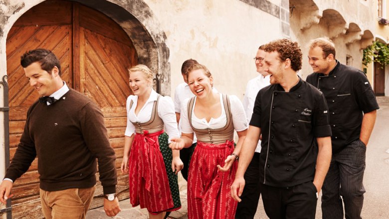 Hofmeisterei Hirtzberger, © Michael Winkelmann Group of people in traditional clothing and cooking uniforms in front of an old building.