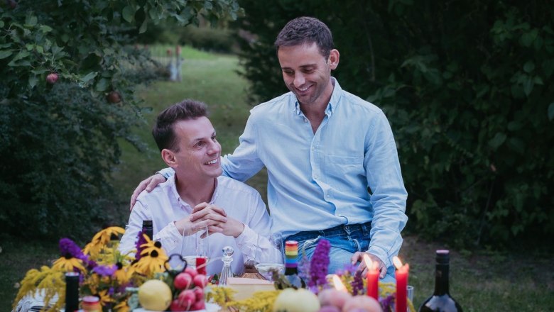 The winemakers Gerald Wunderer and Matthias Lobner, © Stefan Jurecek Two men sit at a table outside, surrounded by flowers and candles.