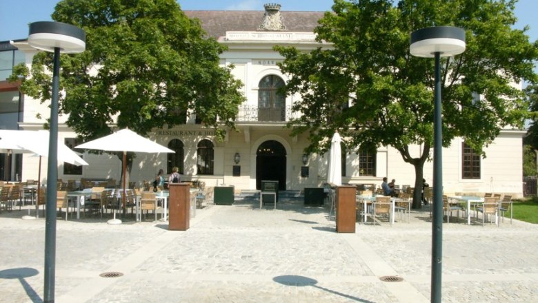 Grafenegg Castle - Tavern, © Mörwald GmbH Exterior view of the tavern in Grafenegg Castle with tables and parasols on the forecourt.