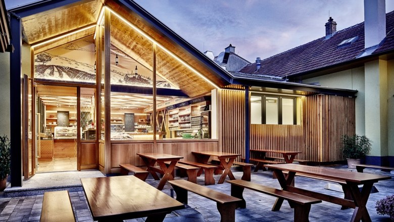 Ott Winery, © www.spitzbart.at Modern winery with wooden elements and outdoor area at dusk.