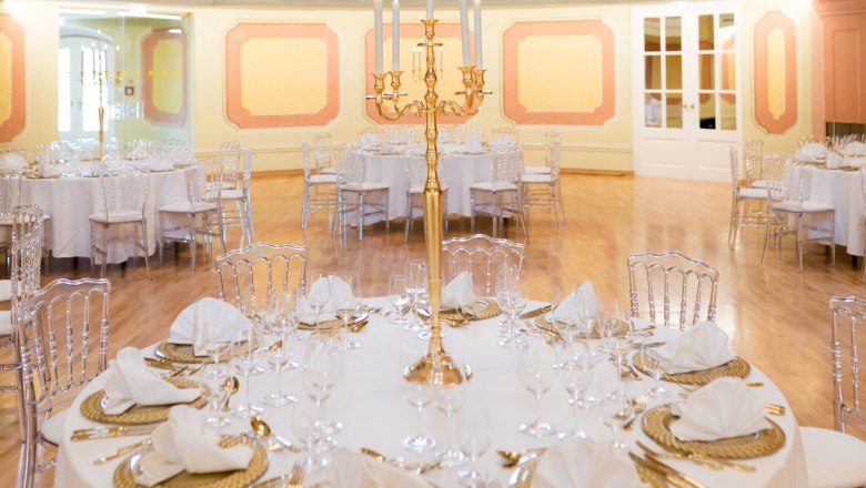 Conference Center Laxenburg, Theatersaal, © Conference Center Laxenburg Elegant theater hall with round, festively laid tables and golden candlesticks.