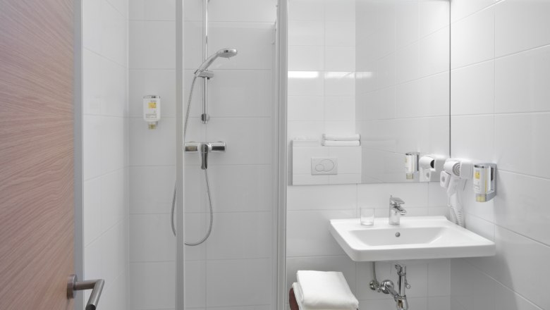 Bathroom Hotel Marc Aurel, Petronell-Carnuntum, © Arion Hotel Gruppe Modern hotel bathroom with shower, washbasin and towels.