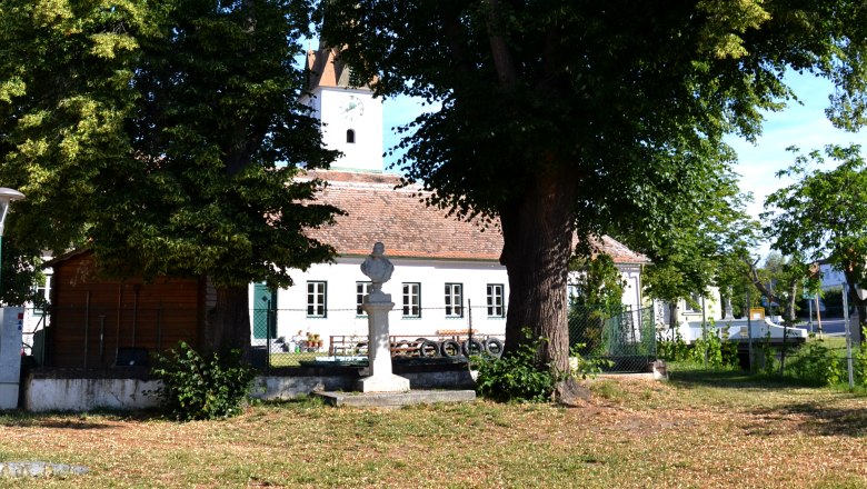 Kaiserplatz Obermarkersdorf, © Stadgemeinde Schrattenthal A square with large trees, a statue and a building in the background.