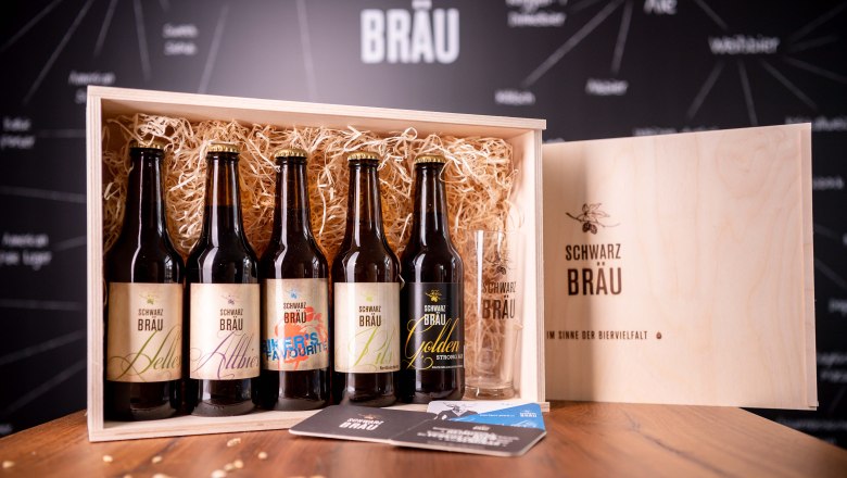 Schwarzbräu beers in the elegant wooden box, © Herbst Elegant wooden box with five Schwarzbräu beer bottles and a glass.