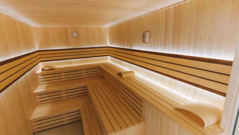 New sauna area, © Sporthotel Semmering Interior view of a modern sauna with wooden benches and soft lighting.