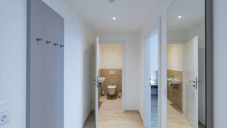 Apartment 3, © Atelier Fürtner-Ton Hallway with a view of the bathroom and mirror on the wall.