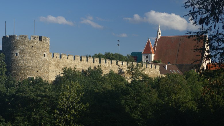 Chancellor's Tower with town wall and parish church, © Veigl Harald Town wall with chancellor's tower and parish church in the background, surrounded by trees.