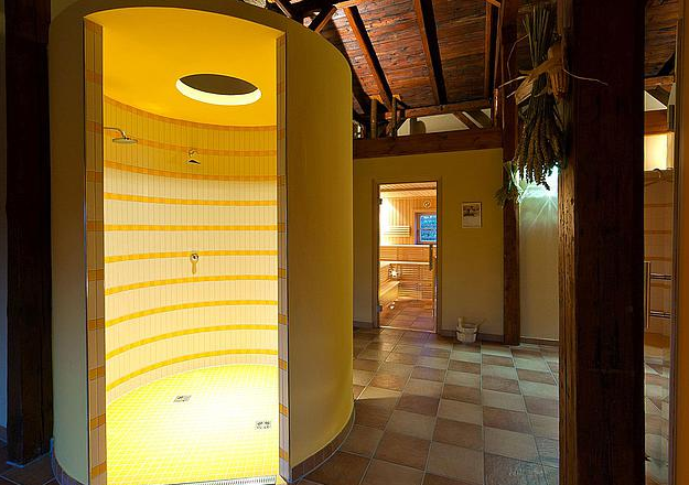 Sauna and relaxation area, © JUFA Interior view of a sauna and relaxation area with shower and wooden beams.