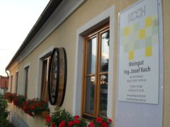 Winery, © Josef Koch Exterior view of a winery with flowers and sign.