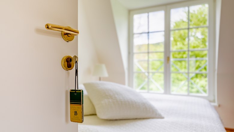 Cavalier houses, © Wiener Alpen / Christian Kremsl Open door with key and sign, behind it a bed and window.