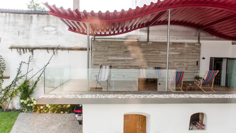 Klinger's guest house, © Astrid Bartl Terrace with red roof and sun loungers in a guest house.