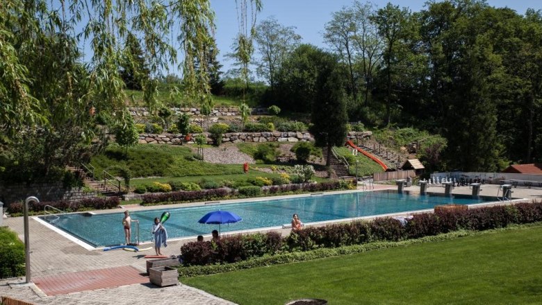Forest pool, © Gemeinde Wölbling An outdoor swimming pool surrounded by trees and lawns.