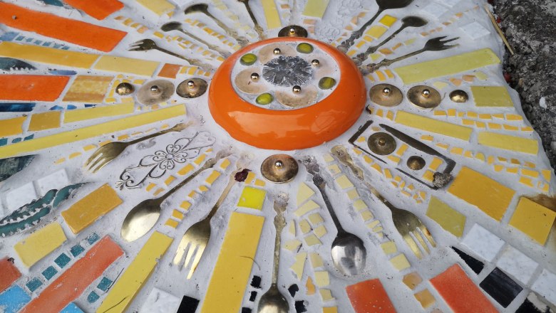Mosaic, © "Natur im Garten" Colorful mosaic with cutlery and ceramic pieces in the shape of the sun.