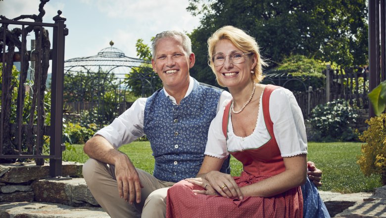 Manuela and Christian Wildeis, © Niederösterreich Werbung/Andreas Hofer The Wildeis family in traditional costume sit smiling in the garden.
