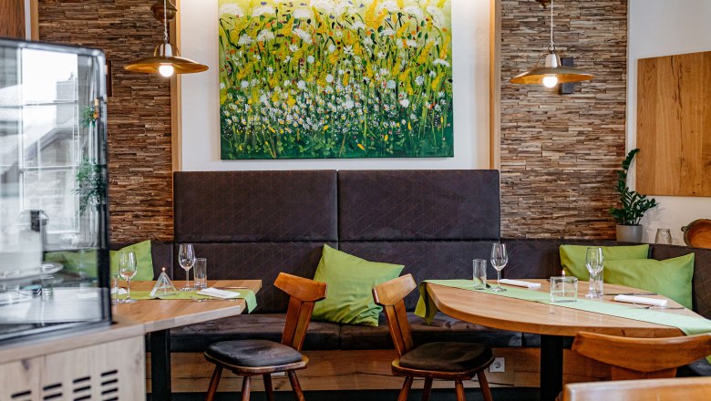 Guest room with lovingly selected details, © Niederösterreich Werbung/Mara Hohla Cozy guest room with wooden furniture, green cushions and a flower picture on the wall.