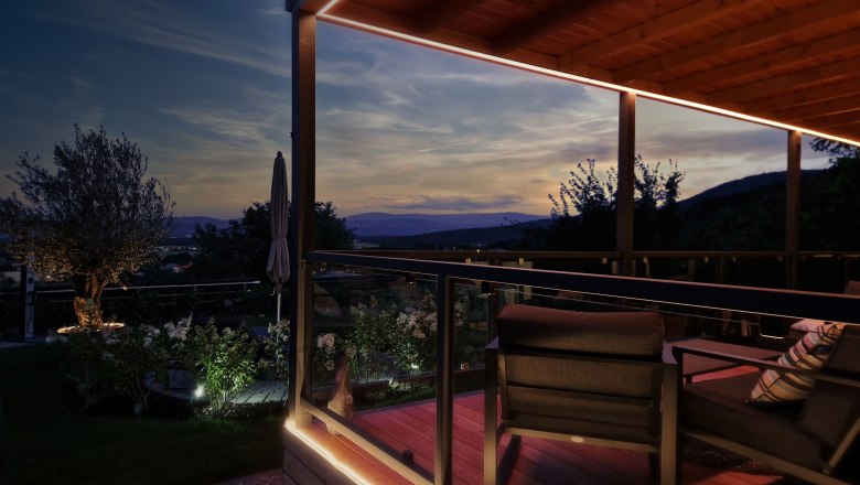 Panorama Johannesbachklamm Chalet, © Johannesbachklamm Chalet Evening atmosphere on a terrace with a view of the mountains and a garden.