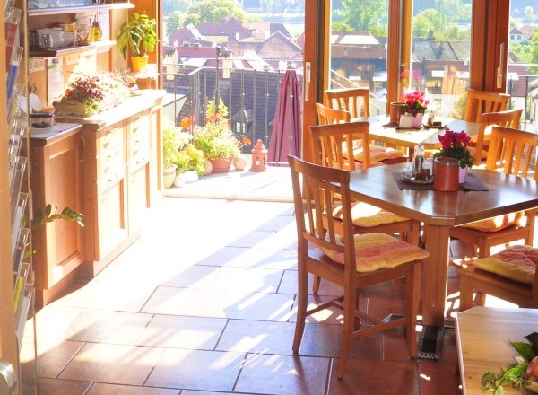 Wachau Tower, © Turm Wachau Interior of a sunny conservatory with wooden furniture and a view of the countryside.