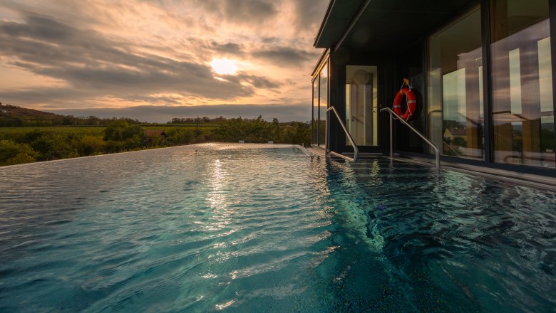 Country estate & SPA Althof Retz, © Niederösterreich Werbung / Maximilian Pawlikowsky Infinity pool with a view of the landscape at sunset.