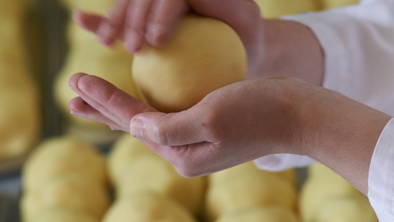 Gasthof Klang Rainer, © Gasthof Klang Rainer Person forming dough ball with hands, other dough balls in the background.