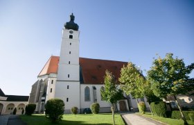 Pilgrimage church Mank, © schwarz-koenig.at Mank pilgrimage church with tower and red roof, surrounded by trees and lawn.