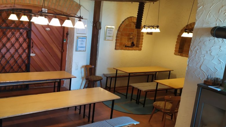 Wine tavern inside, © Weinbau Maier Interior view of a wine tavern with wooden tables, benches and rustic decoration.