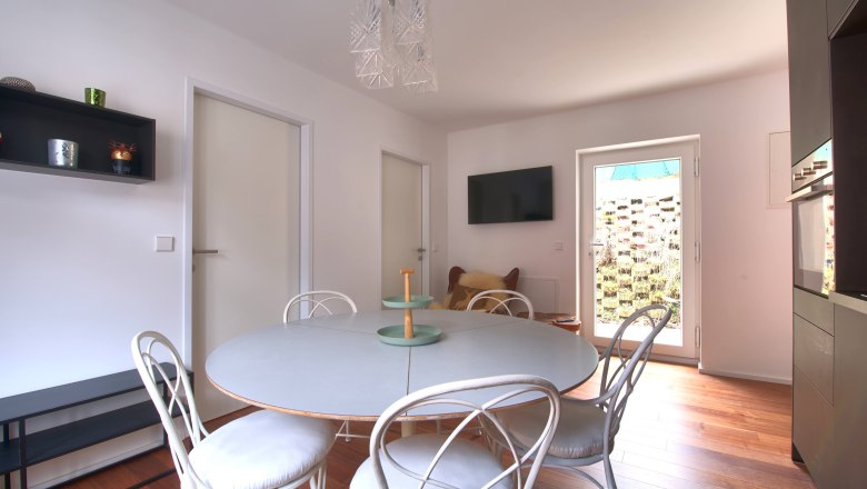 Dining areaTop 3, © Daniela Sinadinoska Modern dining area with round table, white chairs and wooden floor.