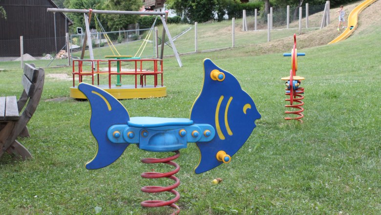 Würflach children's playground, © Gemeinde Würflach Playground with rocking animal in the shape of a fish, carousel and slide.