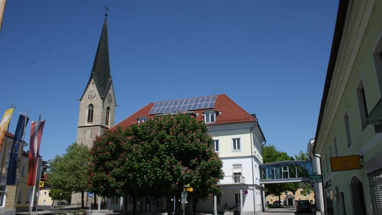 Municipality of St. Valentin, © zVg Gemeinde St. Valentin Church tower and building in St. Valentin with blue sky.
