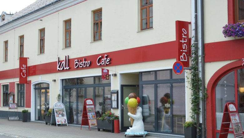 Koll Bistro Kirchschlag, © Koll GmbH Exterior view of the Koll Bistro Café with red sign and polar bear figure with ice cream cone in front of the entrance.