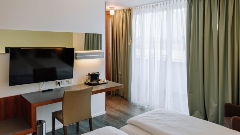 Business terrace HEINhotel vienna airport, © HEINhotel vienna airport Modern hotel room with desk, TV and curtains.
