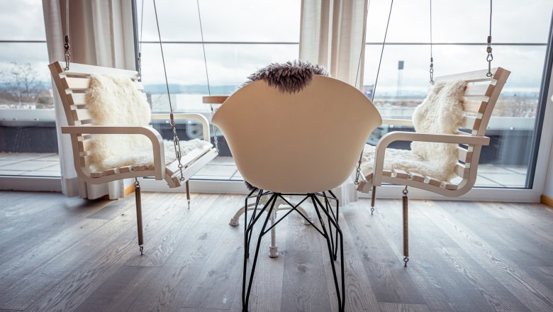 The Alfred, © Niederösterreich Werbung / Maximilian Pawlikowsky Interior with rocking chairs and a modern chair in front of large windows.