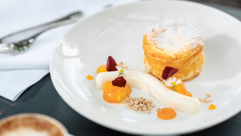 Curd cheese strudel soufflé for dessert, © Niederösterreich Werbung/Michael Reidinger A dessert plate with curd cheese strudel soufflé, vanilla cream, fruit puree and edible flowers.