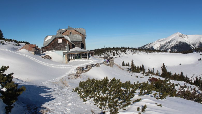 Ottohaus in winter, © Scharfegger´s Raxalpen Resort Winter landscape with the Ottohaus and snow-covered mountains in the background.
