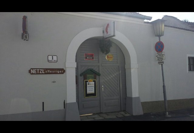 Netzl`s wine tavern, © Donau Niederösterreich Entrance to Netzl's wine tavern with gray door and sign.