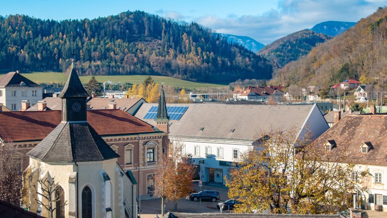 postcard (31) © Municipality of Gloggnitz, photographer Johannes Hartl, © Stadtgemeinde Gloggnitz, Fotograf Johannes Hartl Town view of Gloggnitz with chapel, buildings and wooded hills in the background.