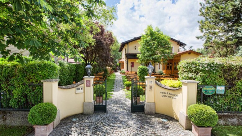 Driveway, © Wein und Heuriger Ganneshofer Entrance to a cozy inn with garden and outdoor seating.