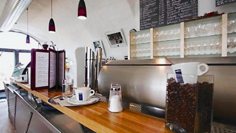 Café & Wine in the Ursin House, © Ursin Haus Interior view of a café with counter, coffee machine and glasses.